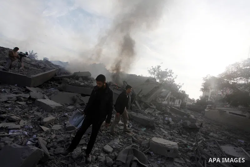 Palestinians look at government offices destroyed in an Israeli airstrike in Gaza City, 21 November 2012. Palestinian militants renewed their rocket fire on Israel 21 November and Israel continued pounding targets in the...