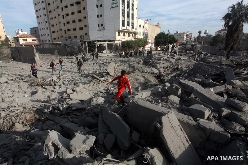 Palestinians look at government offices destroyed in an Israeli airstrike in Gaza City, 21 November 2012. Palestinian militants renewed their rocket fire on Israel 21 November and Israel continued pounding targets in the...