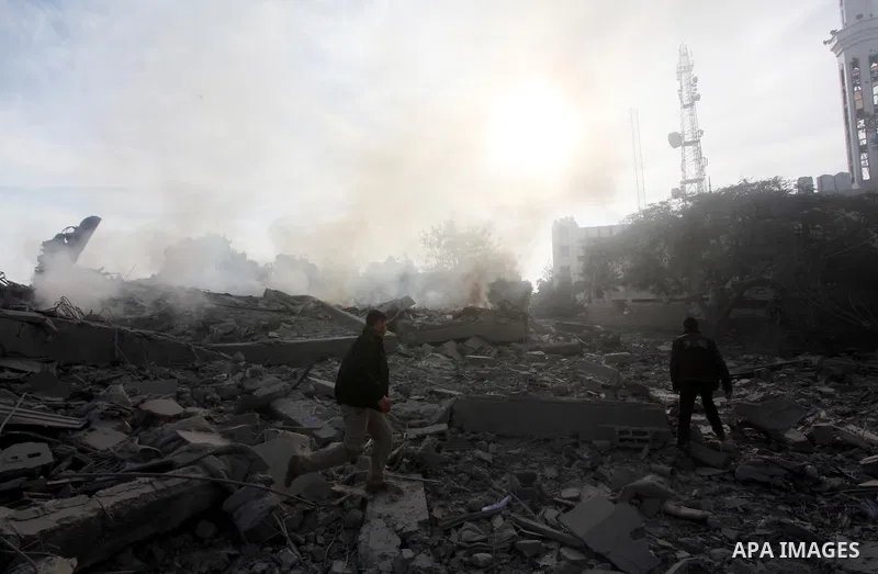 Palestinians look at government offices destroyed in an Israeli airstrike in Gaza City, 21 November 2012. Palestinian militants renewed their rocket fire on Israel 21 November and Israel continued pounding targets in the...