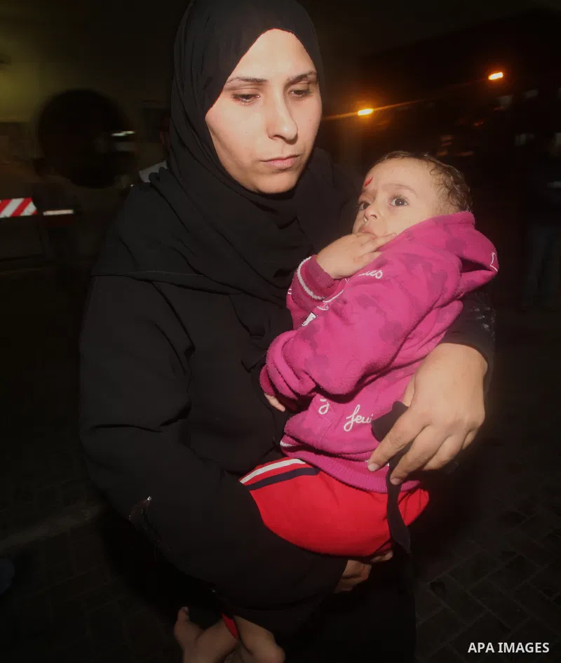 A Palestinian woman carries his wounded babay into al-Shifa hospital after an Israeli airstrike in Gaza city, on November 21, 2012. Israeli leaders discussed an Egyptian plan for a truce with Gaza's ruling Hamas, reports...