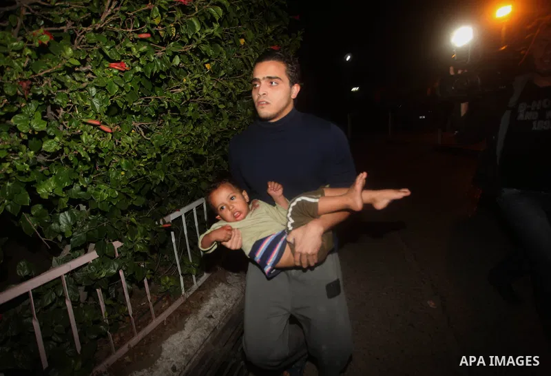 A Palestinian man carries his wounded babay into al-Shifa hospital after an Israeli airstrike in Gaza city, on November 21, 2012. Israeli leaders discussed an Egyptian plan for a truce with Gaza's ruling Hamas, reports s...