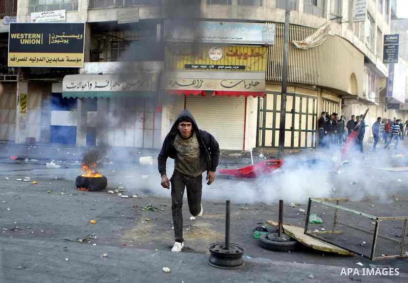 Palestinian youths throw stones during clashes with Israeli troops against Israel's operations in Gaza Strip in the West Bank city of Hebron, Tuesday, Nov. 20, 2012. Photo by Mamoun Wazwazi