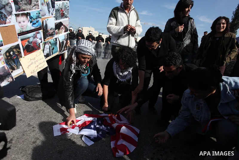 Palestinians protest during the visit of U.S. Secretary of State Hillary Clinton in the West Bank city of Ramallah November 21, 2012. Israeli air strikes shook the Gaza Strip and Palestinian rockets struck across the bor...