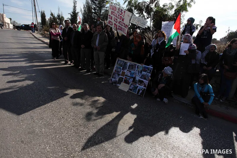 Palestinians protest during the visit of U.S. Secretary of State Hillary Clinton in the West Bank city of Ramallah November 21, 2012. Israeli air strikes shook the Gaza Strip and Palestinian rockets struck across the bor...