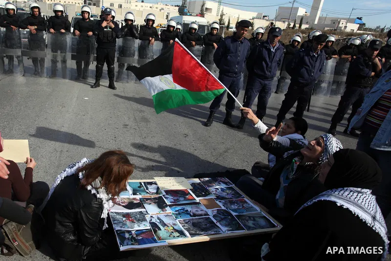 Palestinians protest during the visit of U.S. Secretary of State Hillary Clinton in the West Bank city of Ramallah November 21, 2012. Israeli air strikes shook the Gaza Strip and Palestinian rockets struck across the bor...