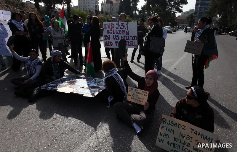 Palestinians protest during the visit of U.S. Secretary of State Hillary Clinton in the West Bank city of Ramallah November 21, 2012. Israeli air strikes shook the Gaza Strip and Palestinian rockets struck across the bor...