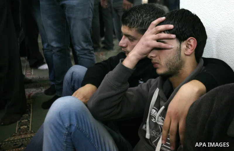 Relatives of Hamdi al Fallah touch his body during his funeral in the West Bank city of Hebron November 20, 2012. Two funeral processions for Palestinians killed during clashes with the Israeli army turned violent on Tue...