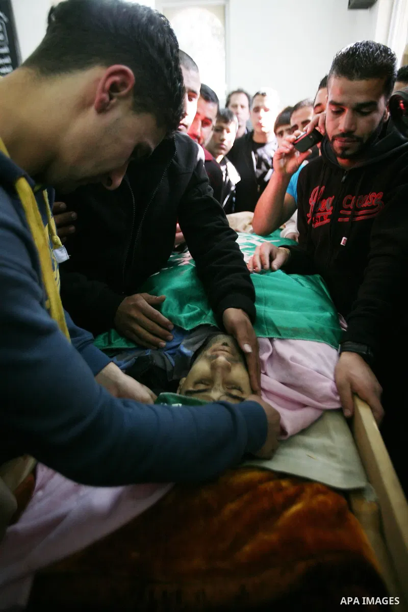 Relatives of Hamdi al Fallah touch his body during his funeral in the West Bank city of Hebron November 20, 2012. Two funeral processions for Palestinians killed during clashes with the Israeli army turned violent on Tue...