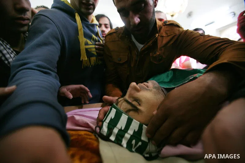 Relatives of Hamdi al Fallah touch his body during his funeral in the West Bank city of Hebron November 20, 2012. Two funeral processions for Palestinians killed during clashes with the Israeli army turned violent on Tue...
