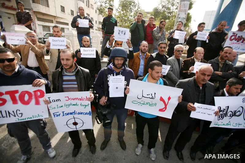 Palestinian Journalists hold placards during a protest against the Israeli targeting the Gazans media members, in the West Bank city of Hebron, November 21, 2012. Two cameramen from Hamas-owned Al-Aqsa TV were among six...
