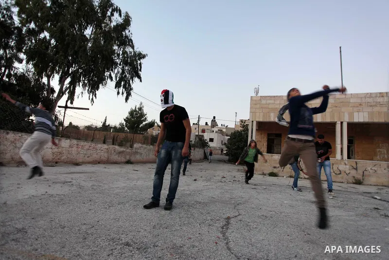 Palestinian protester throw stones at Israeli security forces during clashes in the West Bank village in Nabi Saleh, near Ramallah November 20, 2012. Two funeral processions for Palestinians killed during clashes with th...