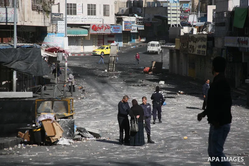 Palestinians walk in a street as shops closed against a lockout against the Israeli military action on Gaza strip, in the West Bank city of Hebron, November 21, 2012. Israeli air strikes shook the Gaza Strip and Palestin...