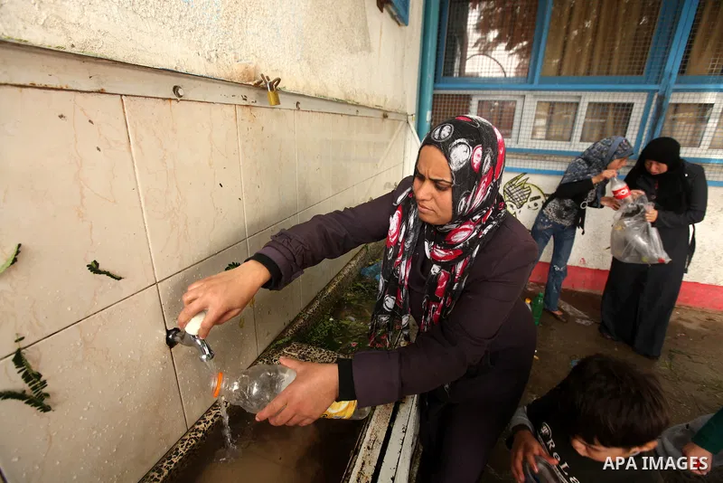 Palestinians gather where displaced families are staying after evacuating their homes earlier this week to take shelter at a United Nations (UN) school in Gaza City on November 21, 2012. Palestinian president Mahmud Abba...
