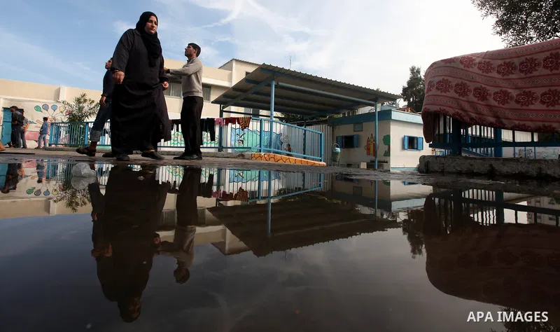 Palestinians gather where displaced families are staying after evacuating their homes earlier this week to take shelter at a United Nations (UN) school in Gaza City on November 21, 2012. Palestinian president Mahmud Abba...