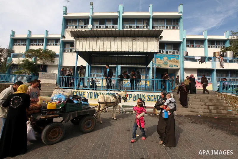 Palestinians gather where displaced families are staying after evacuating their homes earlier this week to take shelter at a United Nations (UN) school in Gaza City on November 21, 2012. Palestinian president Mahmud Abba...