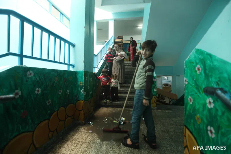 Palestinians gather where displaced families are staying after evacuating their homes earlier this week to take shelter at a United Nations (UN) school in Gaza City on November 21, 2012. Palestinian president Mahmud Abba...