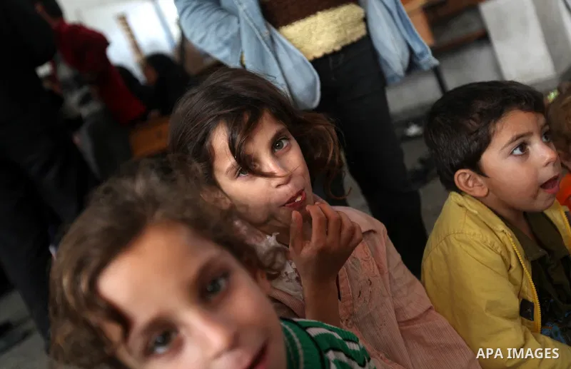 Palestinians gather where displaced families are staying after evacuating their homes earlier this week to take shelter at a United Nations (UN) school in Gaza City on November 21, 2012. Palestinian president Mahmud Abba...