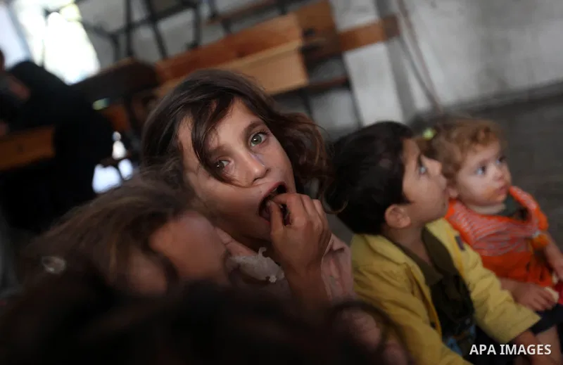 Palestinians gather where displaced families are staying after evacuating their homes earlier this week to take shelter at a United Nations (UN) school in Gaza City on November 21, 2012. Palestinian president Mahmud Abba...