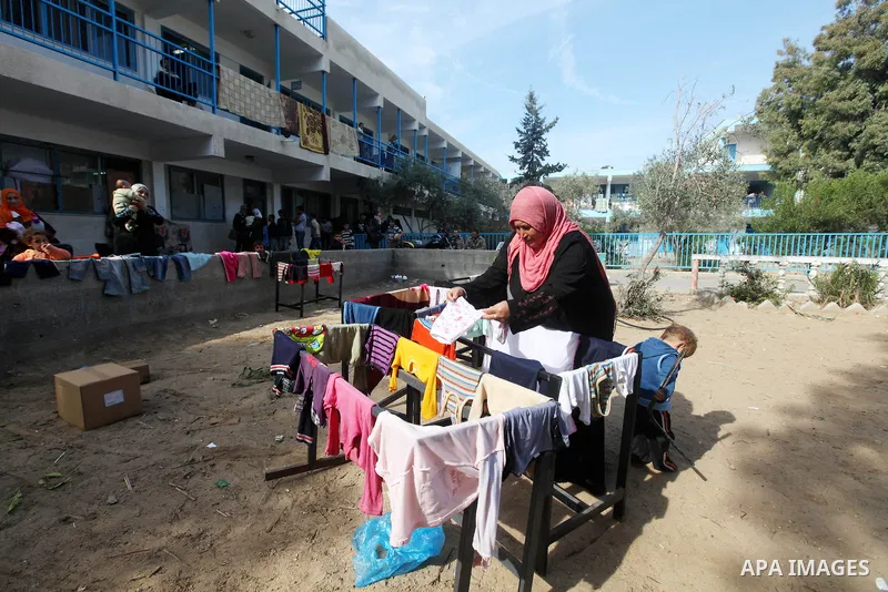 Palestinians gather where displaced families are staying after evacuating their homes earlier this week to take shelter at a United Nations (UN) school in Gaza City on November 21, 2012. Palestinian president Mahmud Abba...