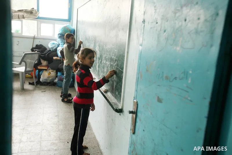 Palestinians gather where displaced families are staying after evacuating their homes earlier this week to take shelter at a United Nations (UN) school in Gaza City on November 21, 2012. Palestinian president Mahmud Abba...