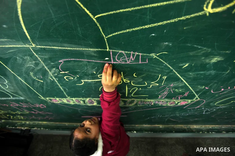 Palestinians gather where displaced families are staying after evacuating their homes earlier this week to take shelter at a United Nations (UN) school in Gaza City on November 21, 2012. Palestinian president Mahmud Abba...