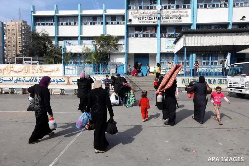 Palestinians gather where displaced families are staying after evacuating their homes earlier this week to take shelter at a United Nations (UN) school in Gaza City on November 21, 2012. Palestinian president Mahmud Abba...