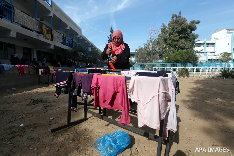 Palestinians gather where displaced families are staying after evacuating their homes earlier this week to take shelter at a United Nations (UN) school in Gaza City on November 21, 2012. Palestinian president Mahmud Abba...