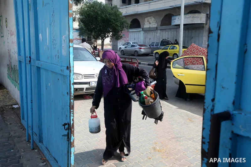 Palestinians gather where displaced families are staying after evacuating their homes earlier this week to take shelter at a United Nations (UN) school in Gaza City on November 21, 2012. Palestinian president Mahmud Abba...