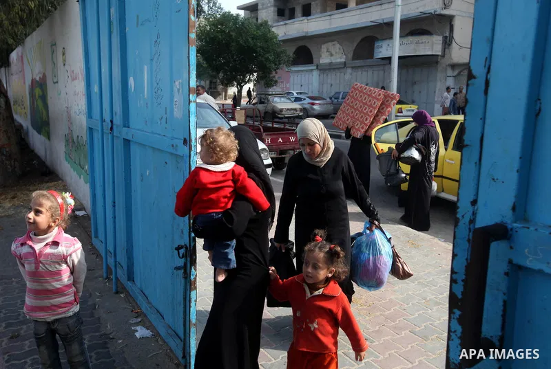 Palestinians gather where displaced families are staying after evacuating their homes earlier this week to take shelter at a United Nations (UN) school in Gaza City on November 21, 2012. Palestinian president Mahmud Abba...