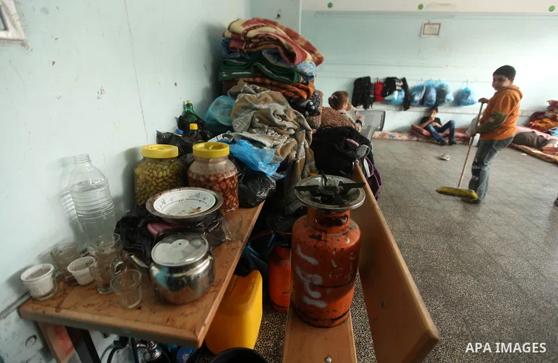 Palestinians gather where displaced families are staying after evacuating their homes earlier this week to take shelter at a United Nations (UN) school in Gaza City on November 21, 2012. Palestinian president Mahmud Abba...