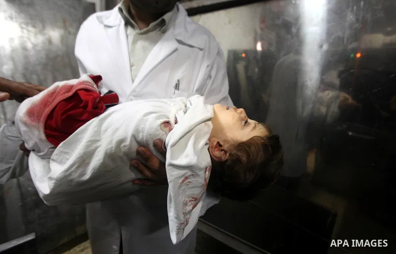 A Palestinian medic carries the body of two years-old Abdel Rahman Majdi Naim, after he was killed in an Israeli strike in Gaza City on November 21, 2012. Naim was killed in a second Israeli strike on the building housin...
