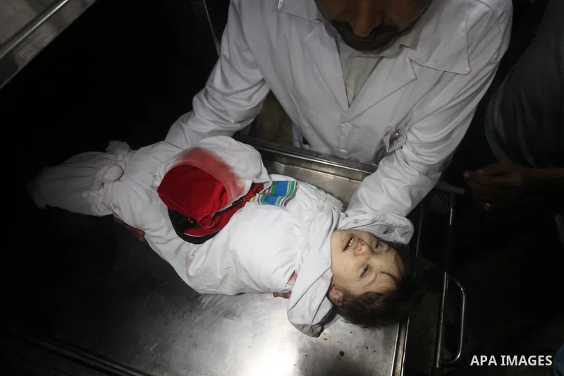 A Palestinian medic carries the body of two years-old Abdel Rahman Majdi Naim, after he was killed in an Israeli strike in Gaza City on November 21, 2012. Naim was killed in a second Israeli strike on the building housin...
