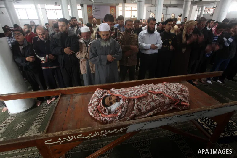Palestinian mourners pray around the body of Mohammed Ashour, 10, killed the previous day in an Israeli air strike on Gaza City, during his funeral, Wednesday, Nov. 21, 2012. Israeli aircraft pounded Gaza with at least 3...