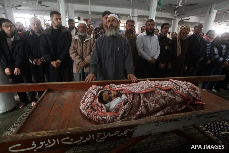 Palestinian mourners pray around the body of Mohammed Ashour, 10, killed the previous day in an Israeli air strike on Gaza City, during his funeral, Wednesday, Nov. 21, 2012. Israeli aircraft pounded Gaza with at least 3...