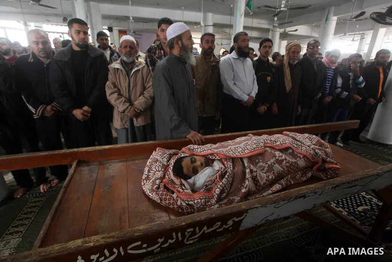 Palestinian mourners pray around the body of Mohammed Ashour, 10, killed the previous day in an Israeli air strike on Gaza City, during his funeral, Wednesday, Nov. 21, 2012. Israeli aircraft pounded Gaza with at least 3...