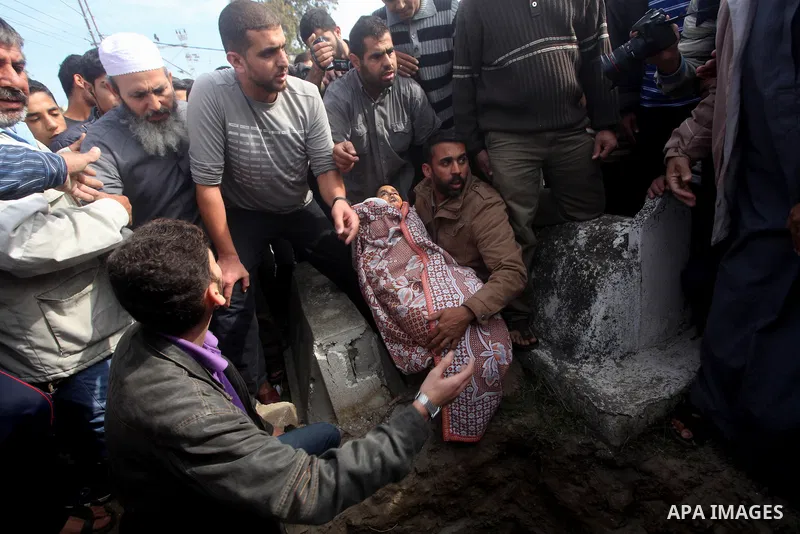 A Palestinian man carries the body of Mohammed Ashour, 10, killed the previous day in an Israeli air strike on Gaza City, during his funeral, Wednesday, Nov. 21, 2012. Israeli aircraft pounded Gaza with at least 30 strik...