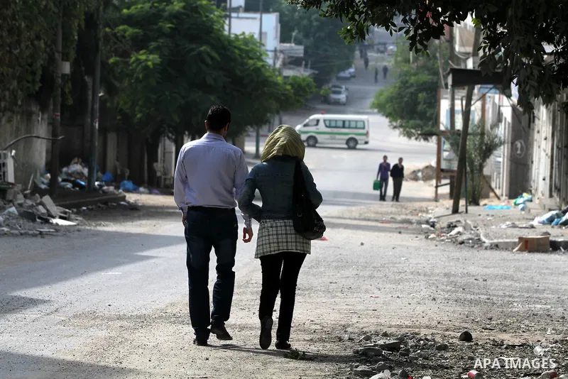 Palestinians walk pass a destroyed gridiron after an israeli air strike in Gaza City, 21 November 2012. Palestinian militants renewed their rocket fire on Israel 21 November and Israel continued pounding targets in the G...