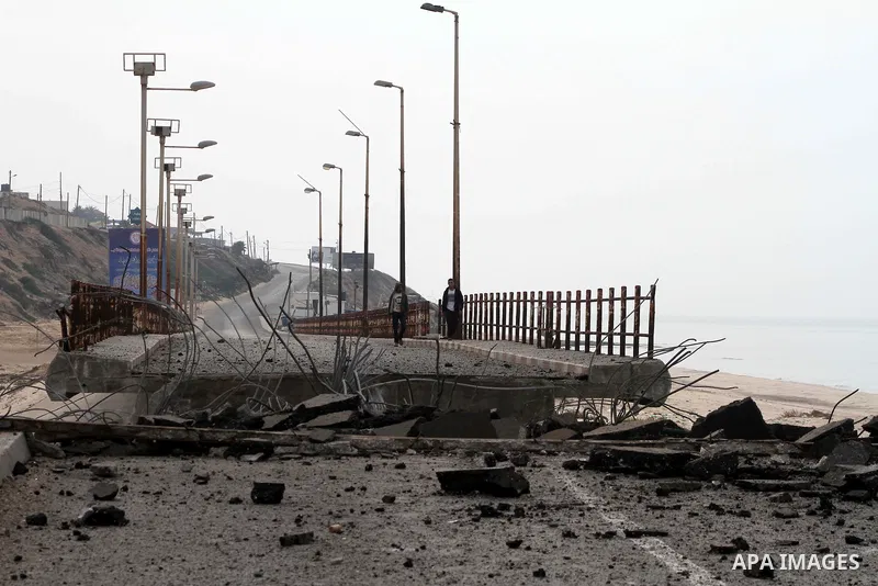 Palestinians look at Wadi Gaza bridge, a strategic link between the northern and southern areas of the Gaza Strip, following an overnight Israeli air strike on November 21, 2012. Today's bloodshed raised to 148 the total...