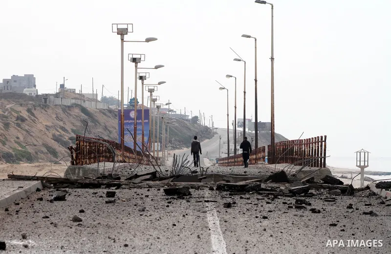 Palestinians look at Wadi Gaza bridge, a strategic link between the northern and southern areas of the Gaza Strip, following an overnight Israeli air strike on November 21, 2012. Today's bloodshed raised to 148 the total...