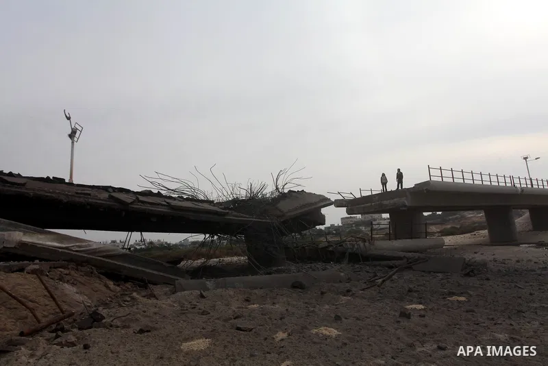 Palestinians look at Wadi Gaza bridge, a strategic link between the northern and southern areas of the Gaza Strip, following an overnight Israeli air strike on November 21, 2012. Today's bloodshed raised to 148 the total...