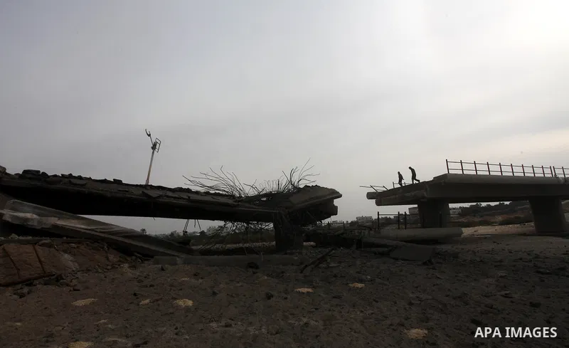 Palestinians look at Wadi Gaza bridge, a strategic link between the northern and southern areas of the Gaza Strip, following an overnight Israeli air strike on November 21, 2012. Today's bloodshed raised to 148 the total...