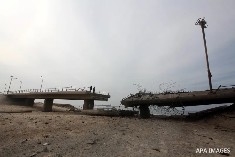 Palestinians look at Wadi Gaza bridge, a strategic link between the northern and southern areas of the Gaza Strip, following an overnight Israeli air strike on November 21, 2012. Today's bloodshed raised to 148 the total...