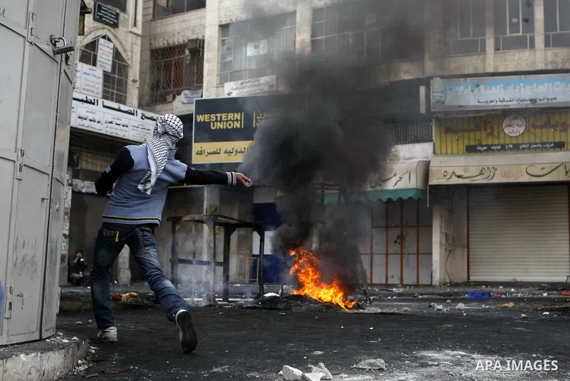 Palestinian stone throwers clash with Israeli border police in the West Bank city of Hebron on November 21, 2012, protesting against the ongoing Israeli military offensive on the Gaza Strip. Israel launched its offensive...