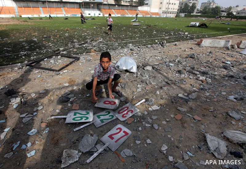 Palestinians inspect the debris of the destroyed Yarmouk Sports Stadium in Gaza City on November 22, 2012, after a ceasefire took hold in and around Gaza after a week of cross-border violence between Israel and Palestini...