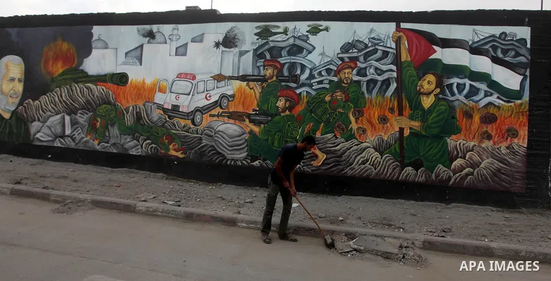 A Palestinian man clean the streets in Gaza City on November 22, 2012, a day after a cease fire was declared between Israel and Hamas. An Egypt-brokered truce took hold in the Gaza Strip after a week of bitter fighting b...
