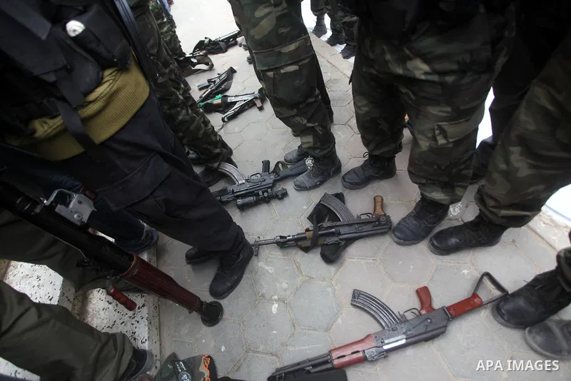 Members of the Ezzedine al-Qassam brigades, the armed wing of Hamas, carry their weapons as they celebrate after the truce between Gaza and Israel came into effect, in the Nusseirat refugee camp in the central Gaza Strip...