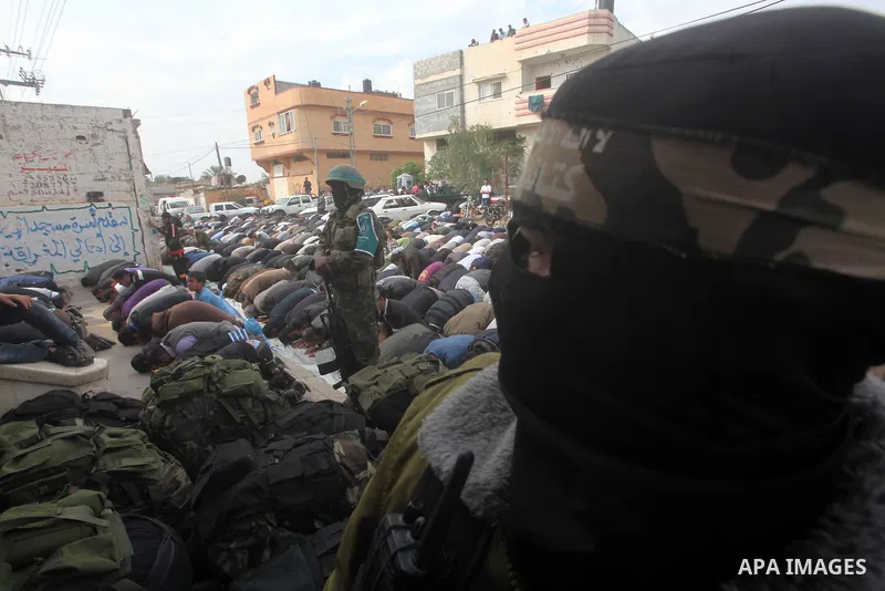 Members of the Ezzedine al-Qassam brigades, the armed wing of Hamas, carry their weapons as they celebrate after the truce between Gaza and Israel came into effect, in the Nusseirat refugee camp in the central Gaza Strip...