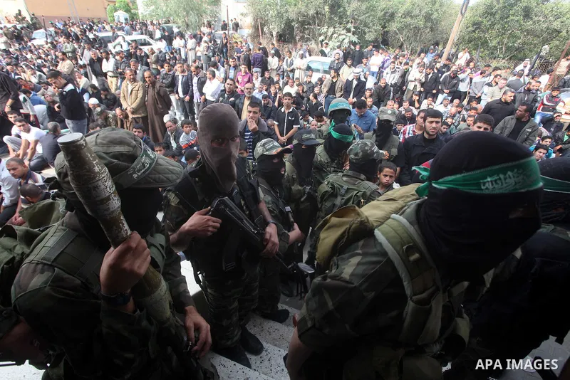 Members of the Ezzedine al-Qassam brigades, the armed wing of Hamas, carry their weapons as they celebrate after the truce between Gaza and Israel came into effect, in the Nusseirat refugee camp in the central Gaza Strip...