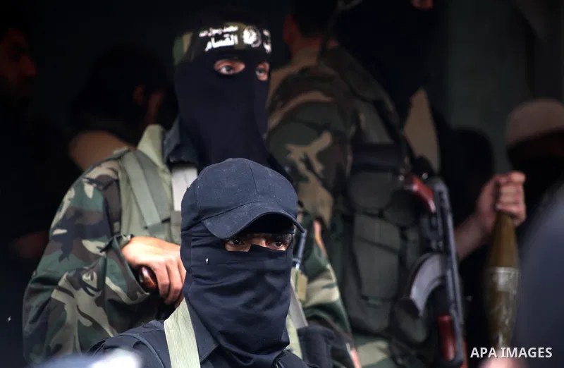 Members of the Ezzedine al-Qassam brigades, the armed wing of Hamas, carry their weapons as they celebrate after the truce between Gaza and Israel came into effect, in the Nusseirat refugee camp in the central Gaza Strip...