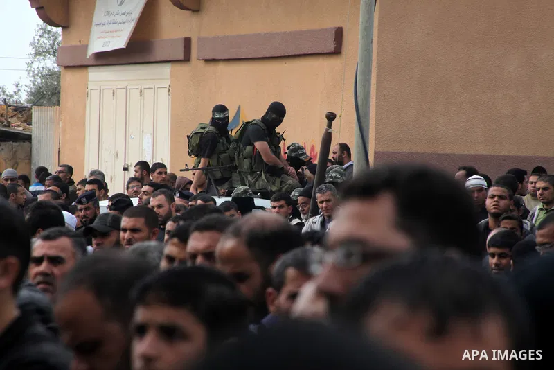 Members of the Ezzedine al-Qassam brigades, the armed wing of Hamas, carry their weapons as they celebrate after the truce between Gaza and Israel came into effect, in the Nusseirat refugee camp in the central Gaza Strip...
